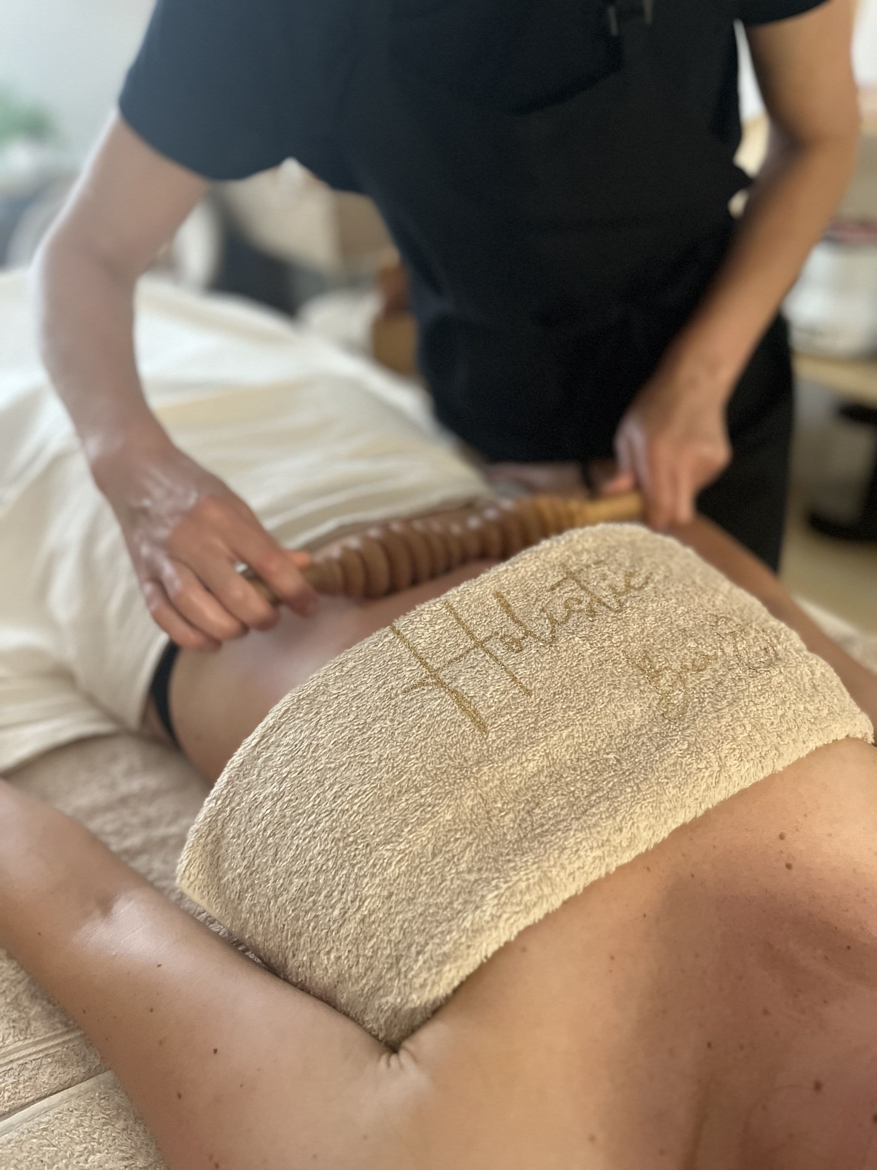 Massage aux outils en bois, geste précis et enveloppant